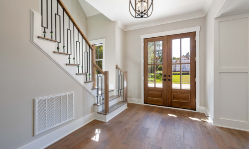An interior door placed next to a homes entryway and staircase.